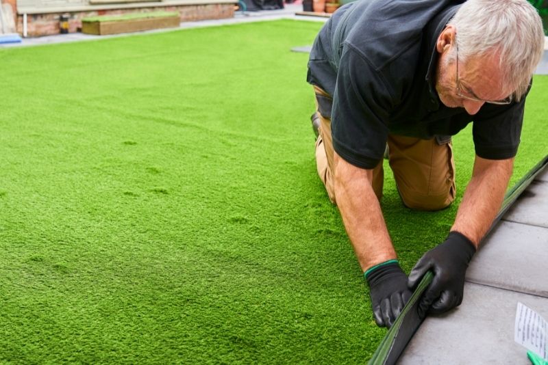 man installing synthetic grass